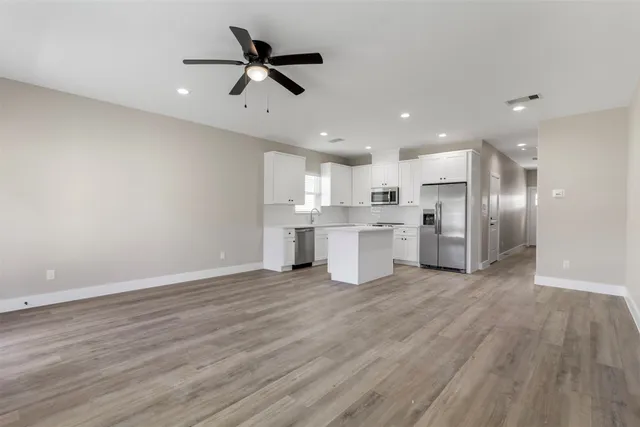 a view of kitchen with stainless steel appliances refrigerator stove microwave and cabinets