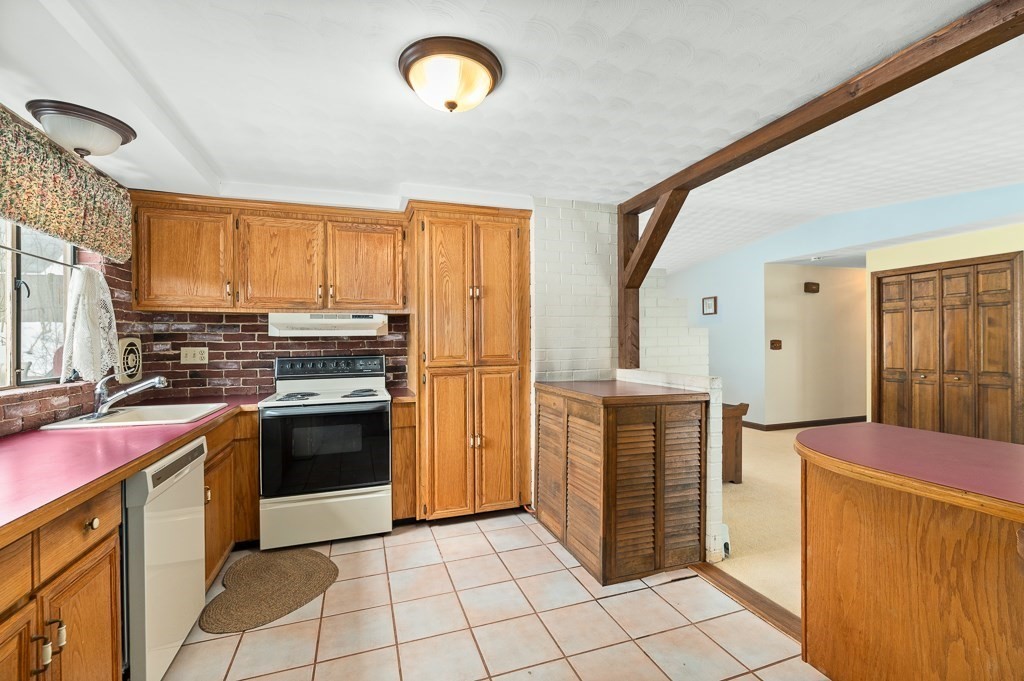 14 Grove Street Danvers, MA 01923 - Photo 7 of 23 a kitchen with a stove top oven and refrigerator