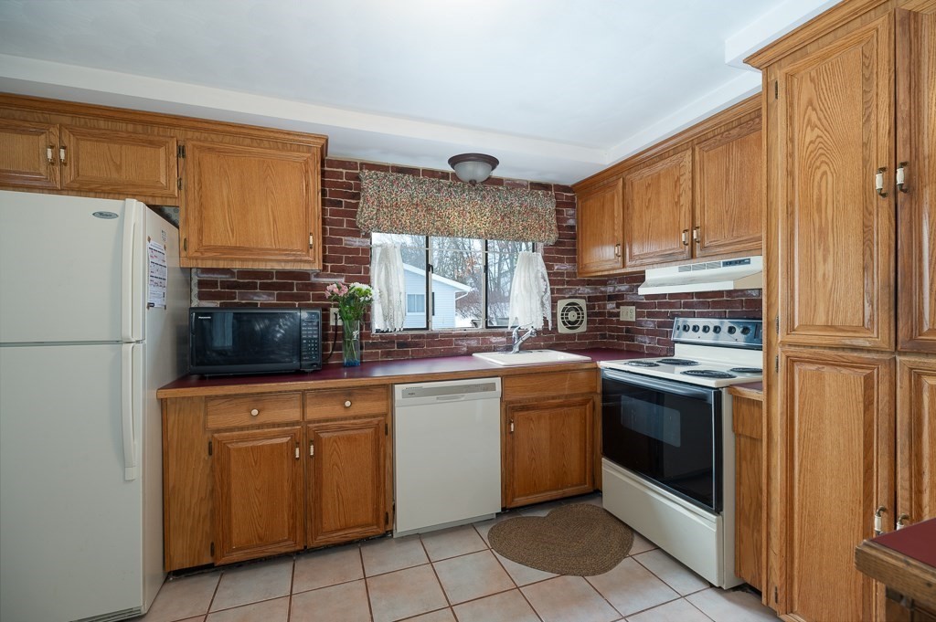 14 Grove Street Danvers, MA 01923 - Photo 8 of 23 a kitchen with stainless steel appliances granite countertop a refrigerator sink and cabinets