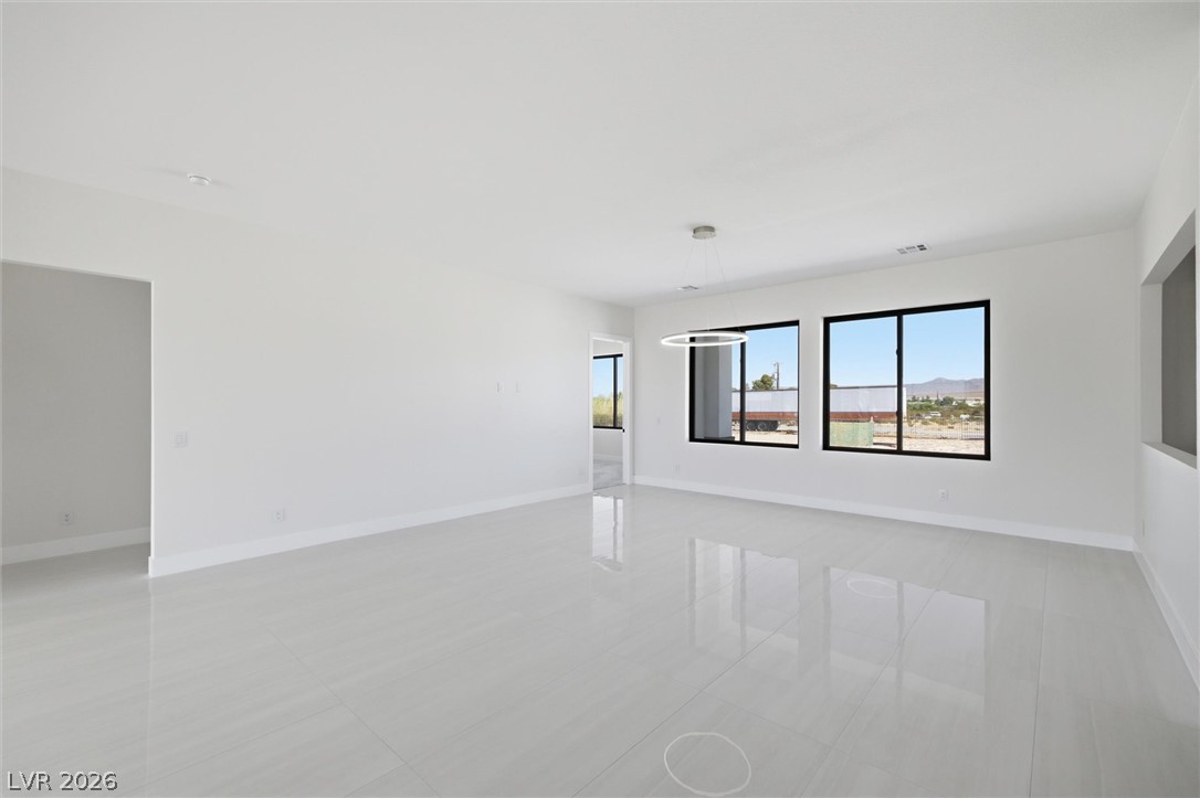 5910 East Kellogg Road Pahrump, NV 89061 - Photo 10 of 58 A spacious, naturally illuminated room boasts crisp white walls and elegant tile flooring.