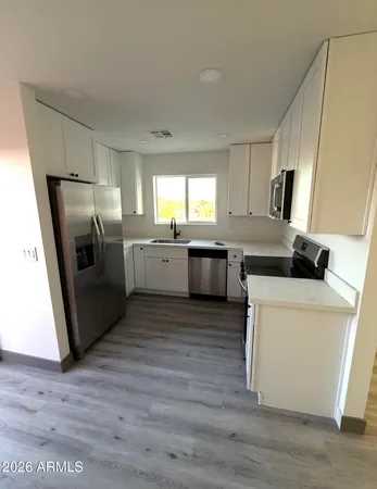 a kitchen with a refrigerator sink and wooden floor
