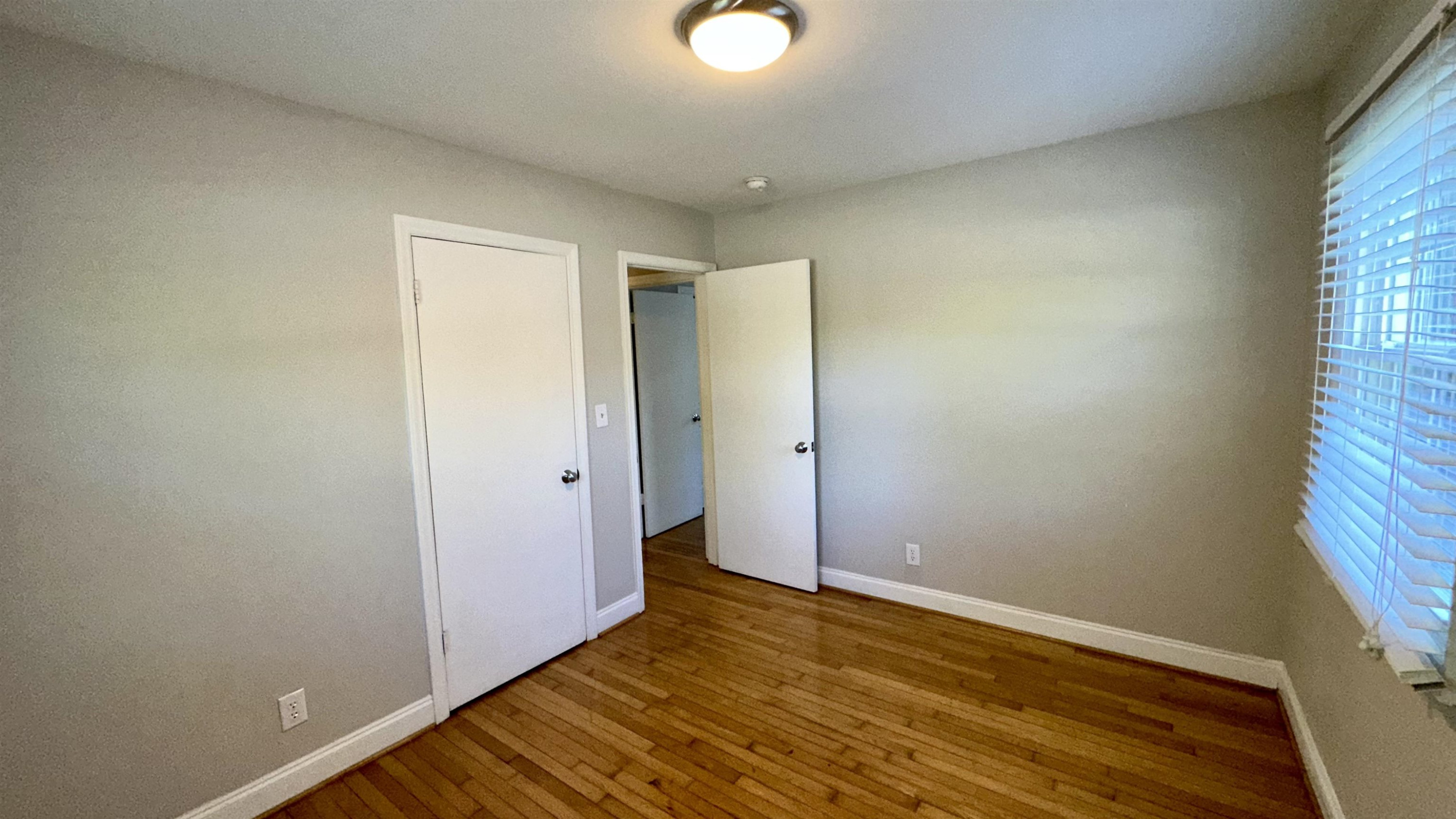 1113 Marlborough Road Raleigh, NC 27610 - Photo 17 of 28 a view of an empty room with wooden floor and a window