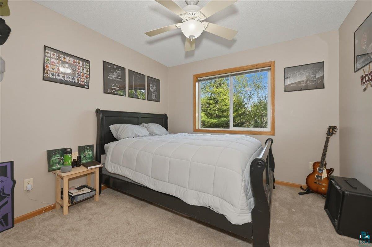 47 Amy Lane Esko, MN 55733 - Photo 22 of 33 Carpeted room featuring a ceiling fan with integrated lighting, a window with wood trim, and light beige walls