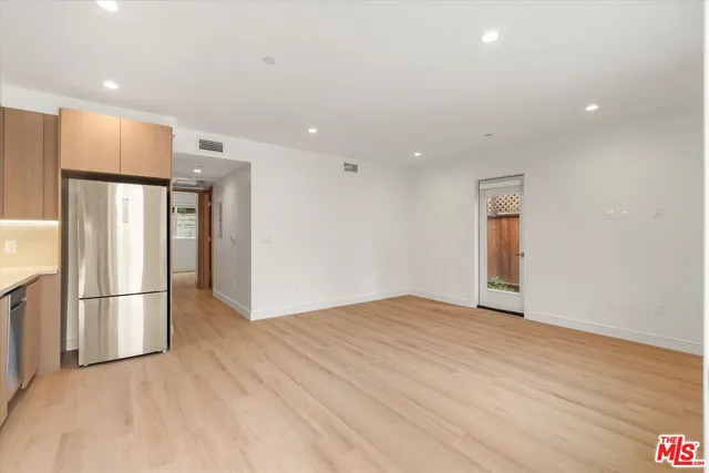 a view of empty room with wooden floor and window