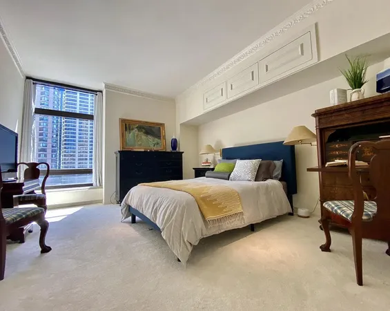 a spacious bedroom with a bed and chair