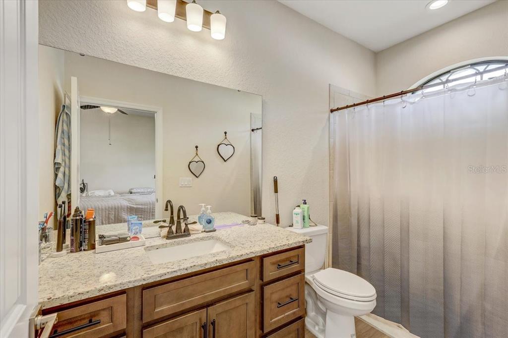 7314 Madrid Road Weeki Wachee, FL 34613 - Photo 20 of 54 a bathroom with a granite countertop sink toilet and shower