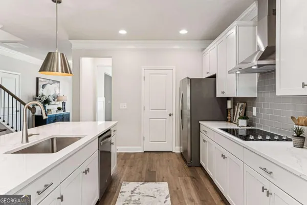 a kitchen with a sink a refrigerator and cabinets