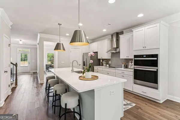 a kitchen with stainless steel appliances a dining table chairs stove and cabinets