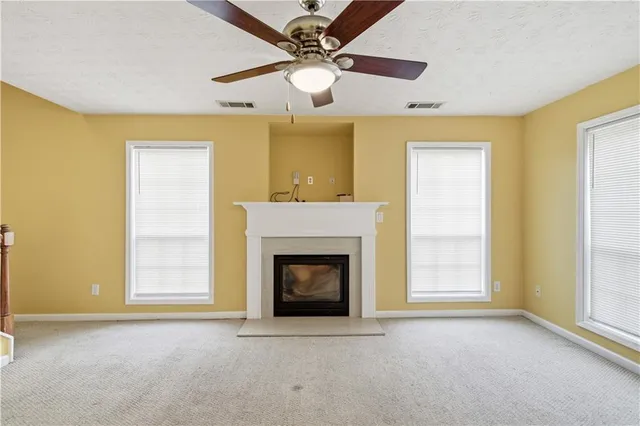 a view of empty room with fireplace and fan