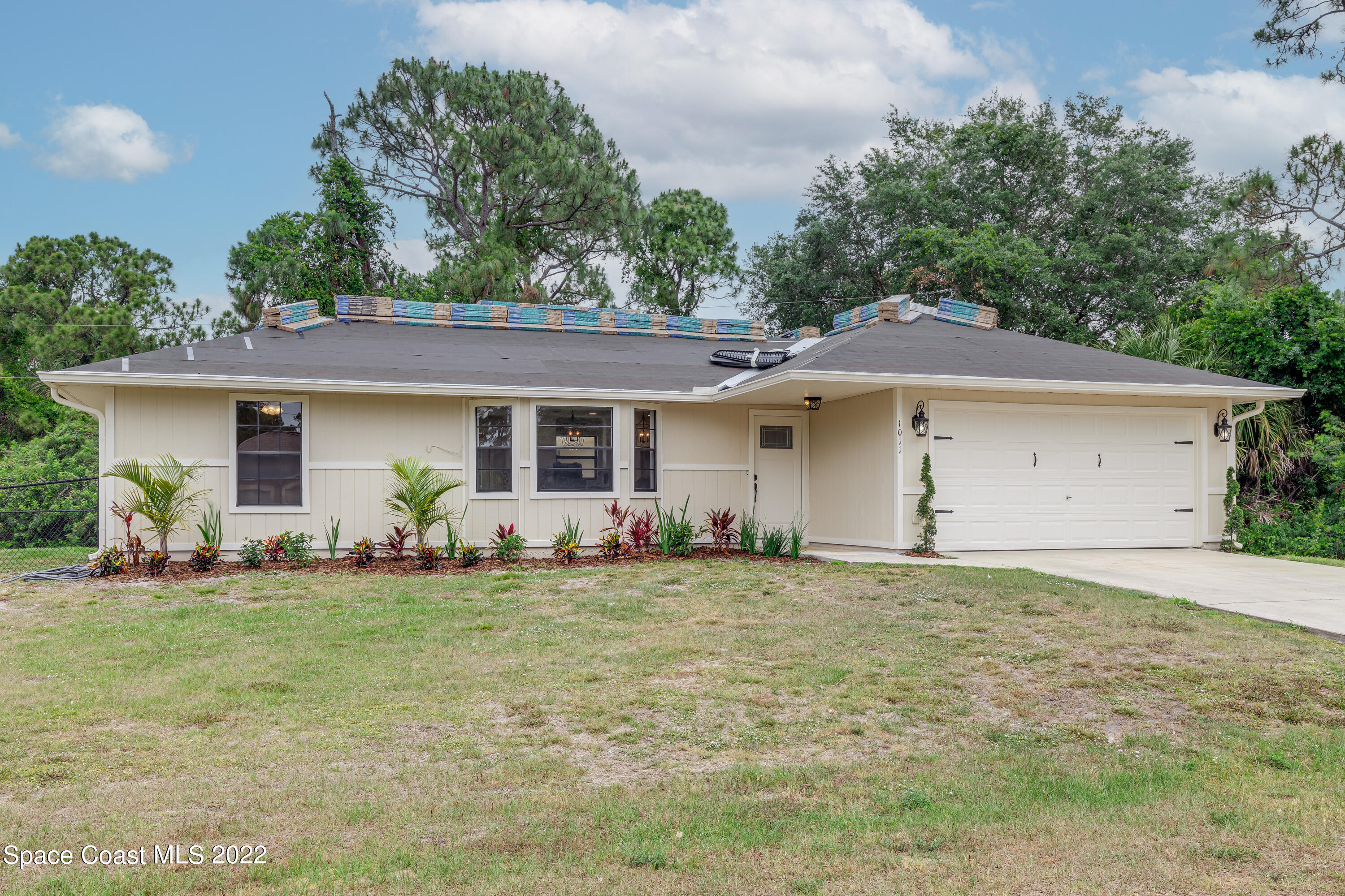 1011 Thompson Road Southwest Palm Bay, FL 32908 - Photo 1 of 17 a front view of a house with a garden and trees