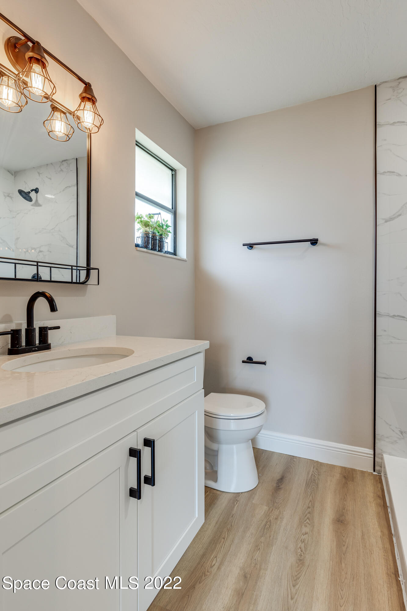 1011 Thompson Road Southwest Palm Bay, FL 32908 - Photo 14 of 17 a bathroom with a sink a toilet and a mirror