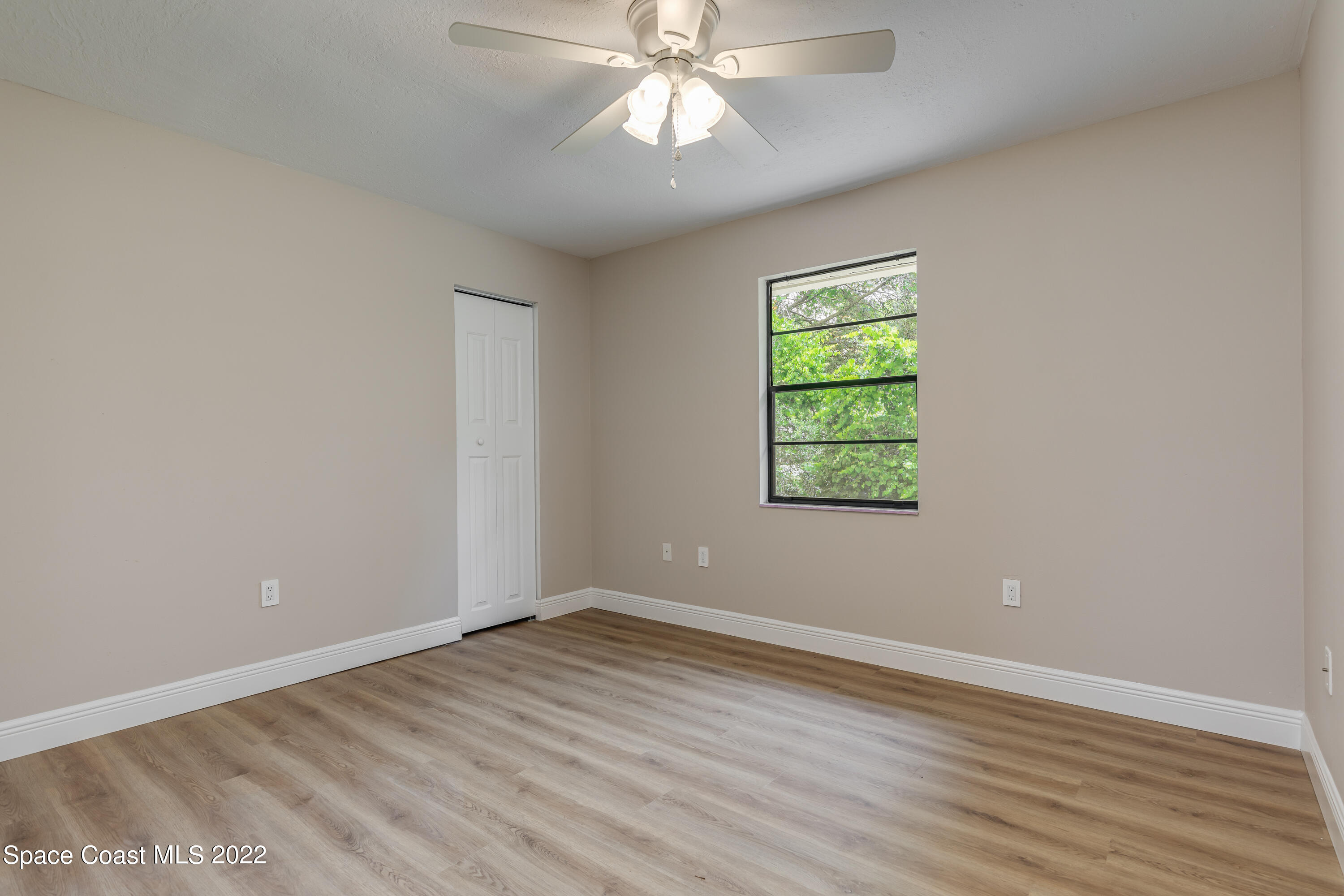 1011 Thompson Road Southwest Palm Bay, FL 32908 - Photo 15 of 17 wooden floor in an empty room with a window