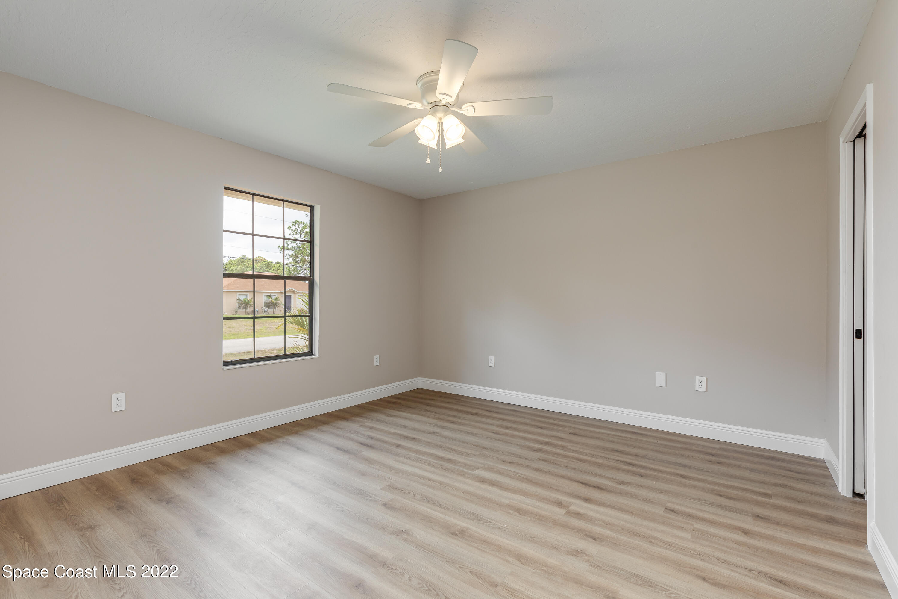 1011 Thompson Road Southwest Palm Bay, FL 32908 - Photo 17 of 17 wooden floor in an empty room with a window