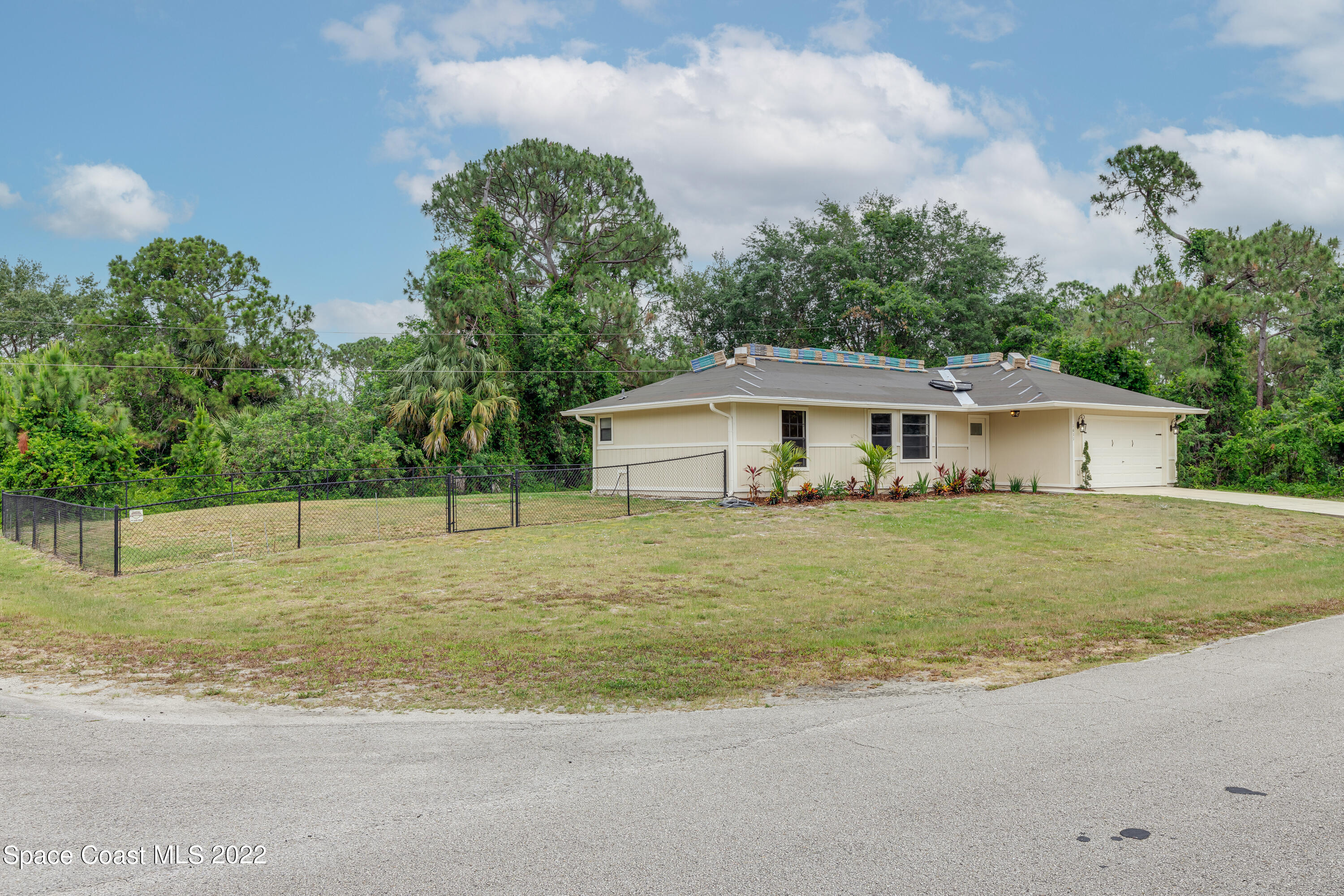 1011 Thompson Road Southwest Palm Bay, FL 32908 - Photo 2 of 17 a front view of house with a garden and trees