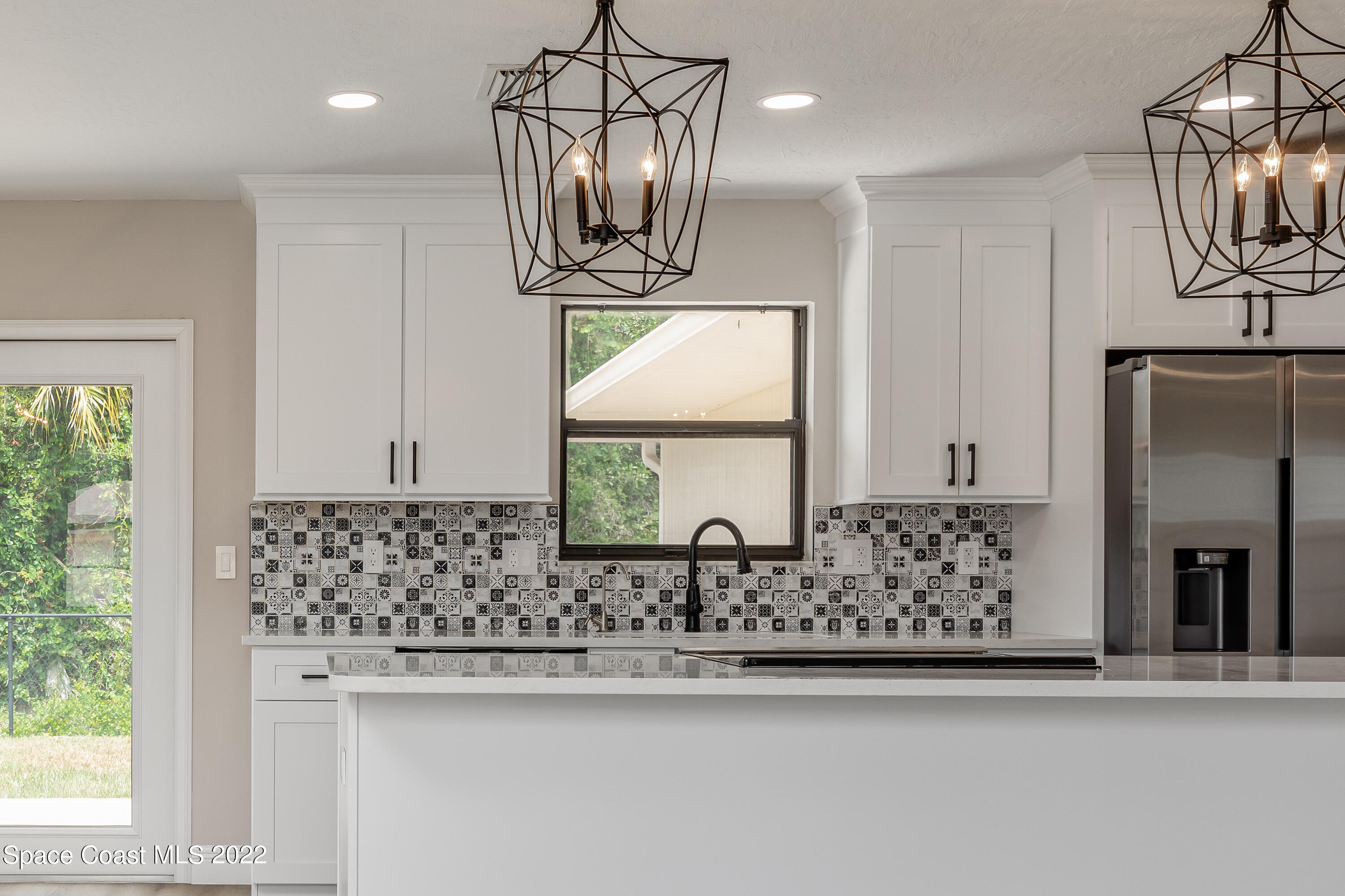 1011 Thompson Road Southwest Palm Bay, FL 32908 - Photo 4 of 17 a kitchen with stainless steel appliances granite countertop a sink and a window