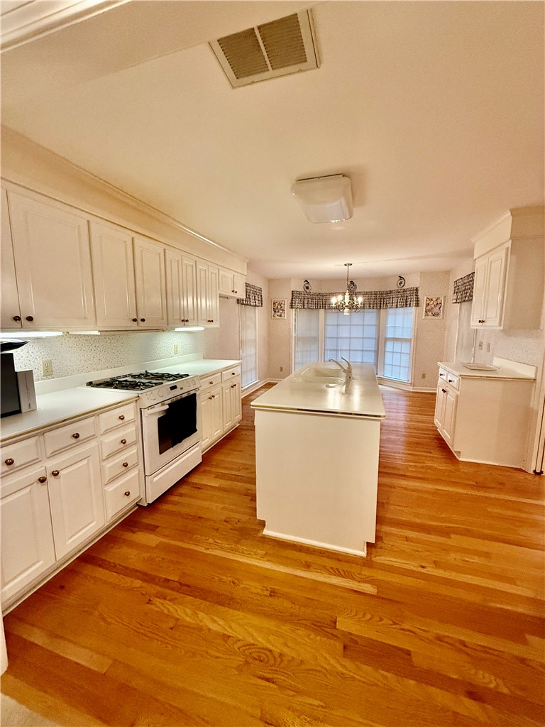 235 Stonehaven Way Seneca, SC 29672 - Photo 18 of 35 A well-appointed kitchen features a central island, ample cabinetry, and rich hardwood flooring, perfect for daily living and entertaining.