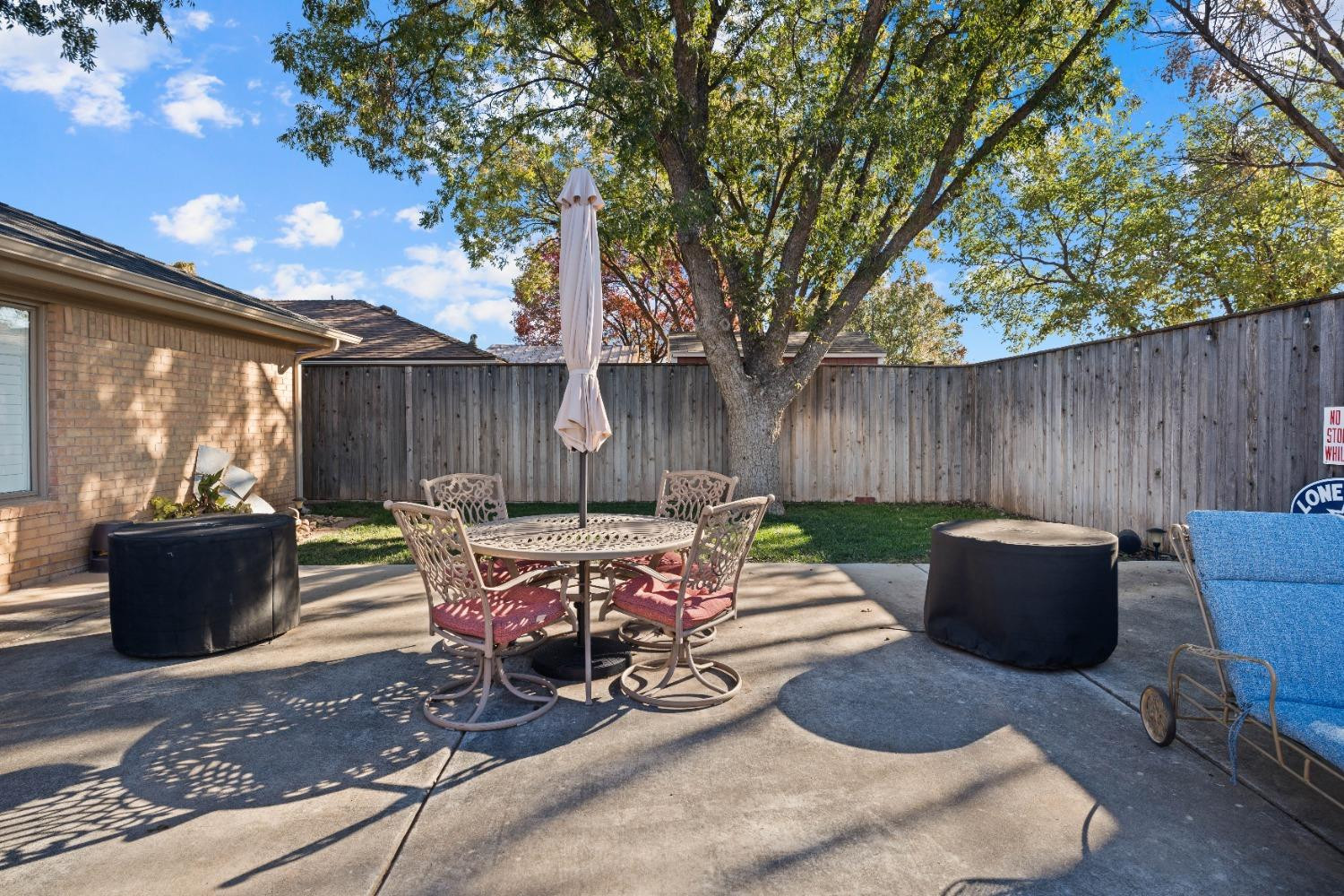 5409 88th Street Lubbock, TX 79424 - Photo 22 of 23 a view of a patio with table and chairs potted plants and wooden fence