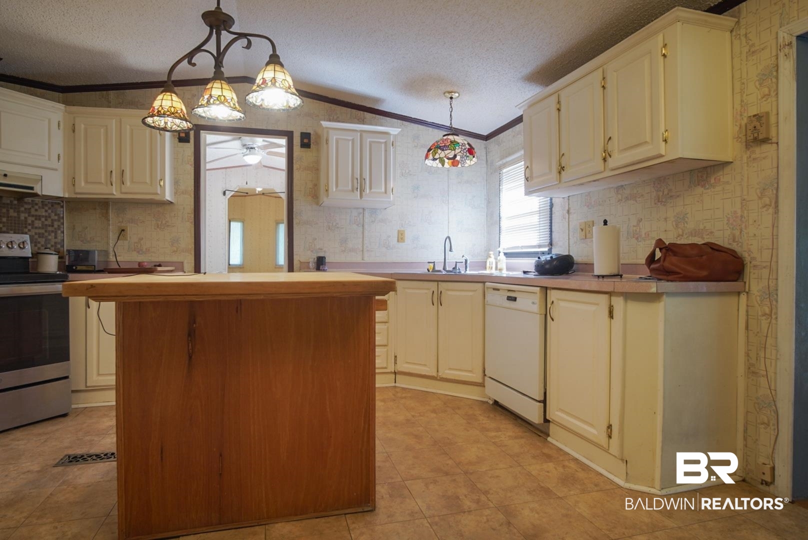 9190 County Road 97 Elberta, AL 36530 - Photo 17 of 53 Kitchen with light tile patterned flooring, dishwasher, crown molding, and stainless steel range with electric stovetop