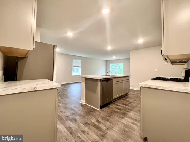 a kitchen with stainless steel appliances kitchen island a sink stove and cabinets