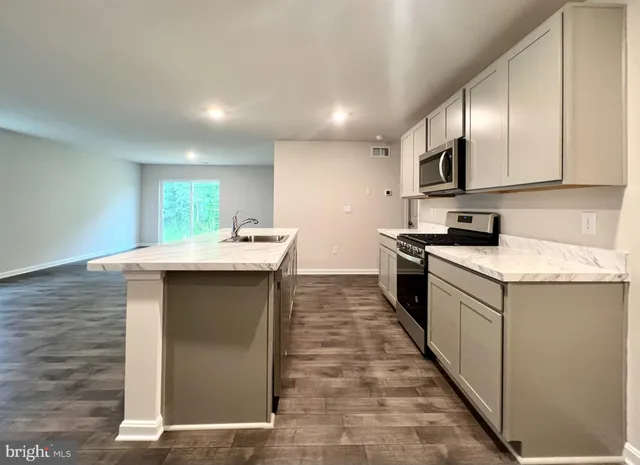 a kitchen with kitchen island granite countertop a sink and counter top space