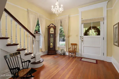 a view of an entryway with wooden floor and livingroom