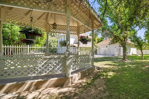 a view of a house with a yard and large tree
