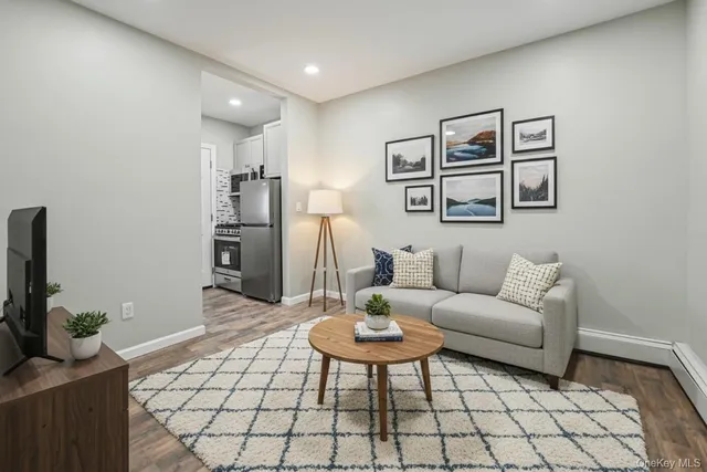 a living room with furniture a flat screen tv and a table