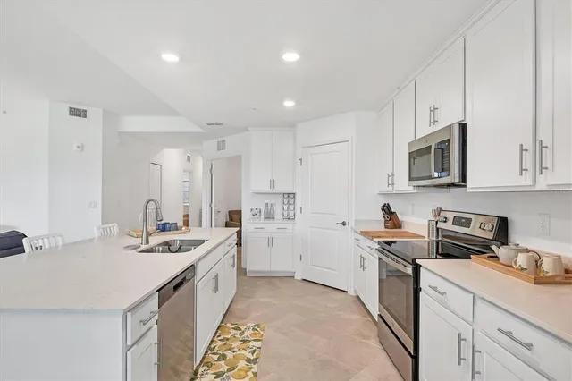 a kitchen with stainless steel appliances kitchen island granite countertop a dining table and chairs