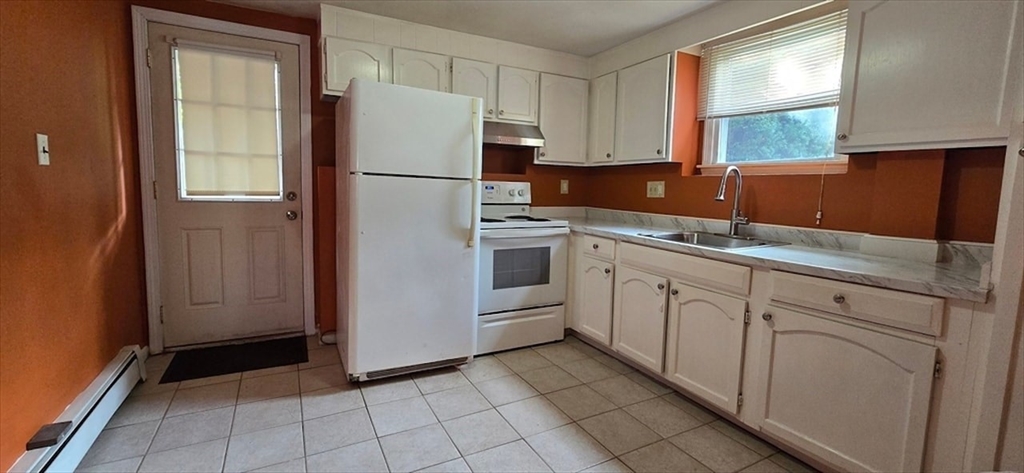 a kitchen with white cabinets and white appliances