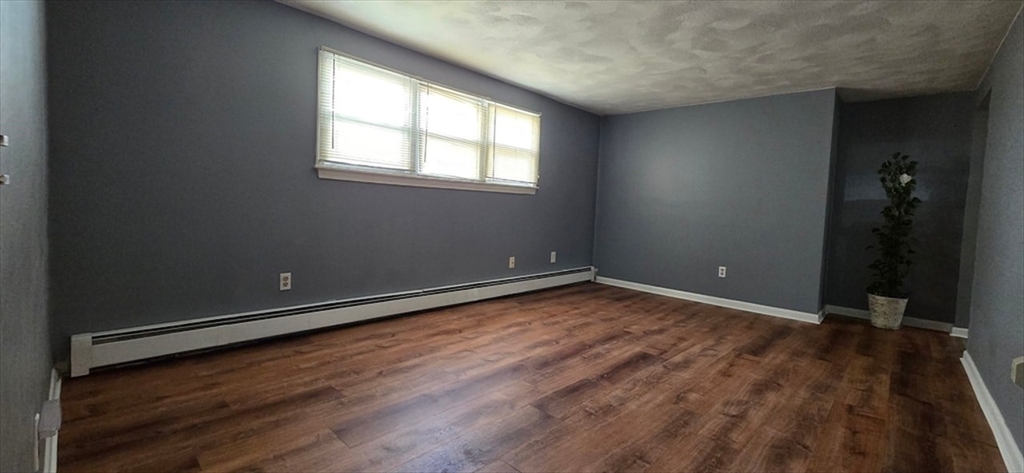 129 Madison Avenue, Unit 2 Arlington, MA 02474 - Photo 2 of 8 an empty room with wooden floor and windows