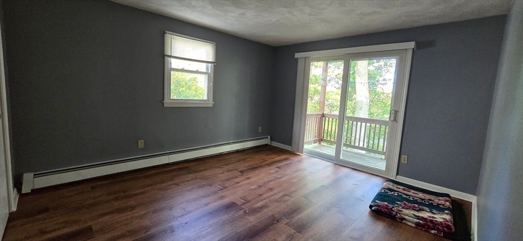 129 Madison Avenue, Unit 2 Arlington, MA 02474 - Photo 3 of 8 an empty room with wooden floor and windows