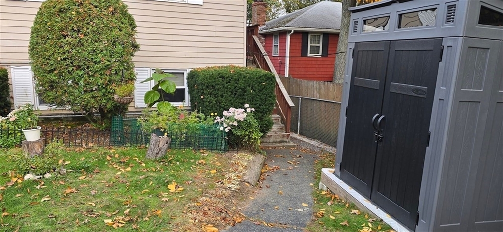 129 Madison Avenue, Unit 2 Arlington, MA 02474 - Photo 8 of 8 a backyard of a house with a garden and plants