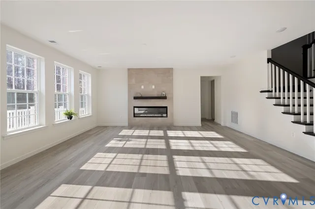 a view of an empty room with a fireplace and a window