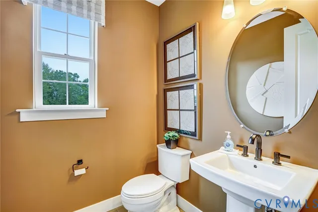 a bathroom with a toilet a sink and a mirror