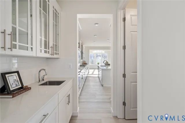 a hallway with a sink and cabinets