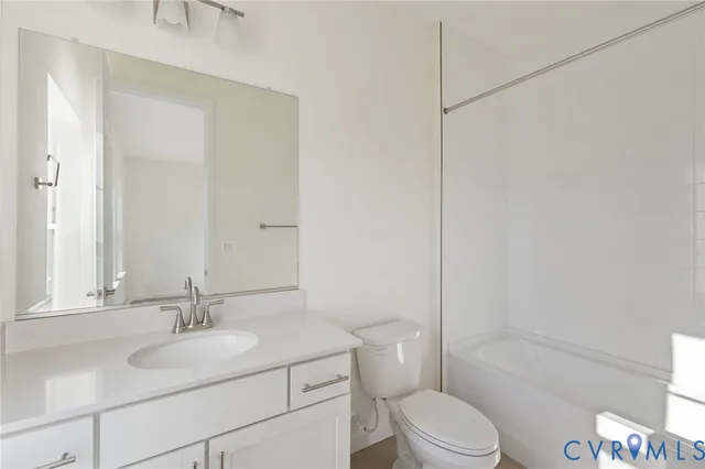 a bathroom with a double vanity sink a toilet a mirror and shower