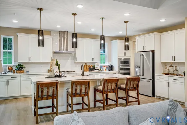 a kitchen with stainless steel appliances granite countertop a table chairs sink refrigerator and microwave