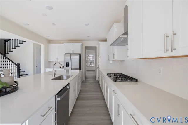 a kitchen with granite countertop a sink a stove and refrigerator