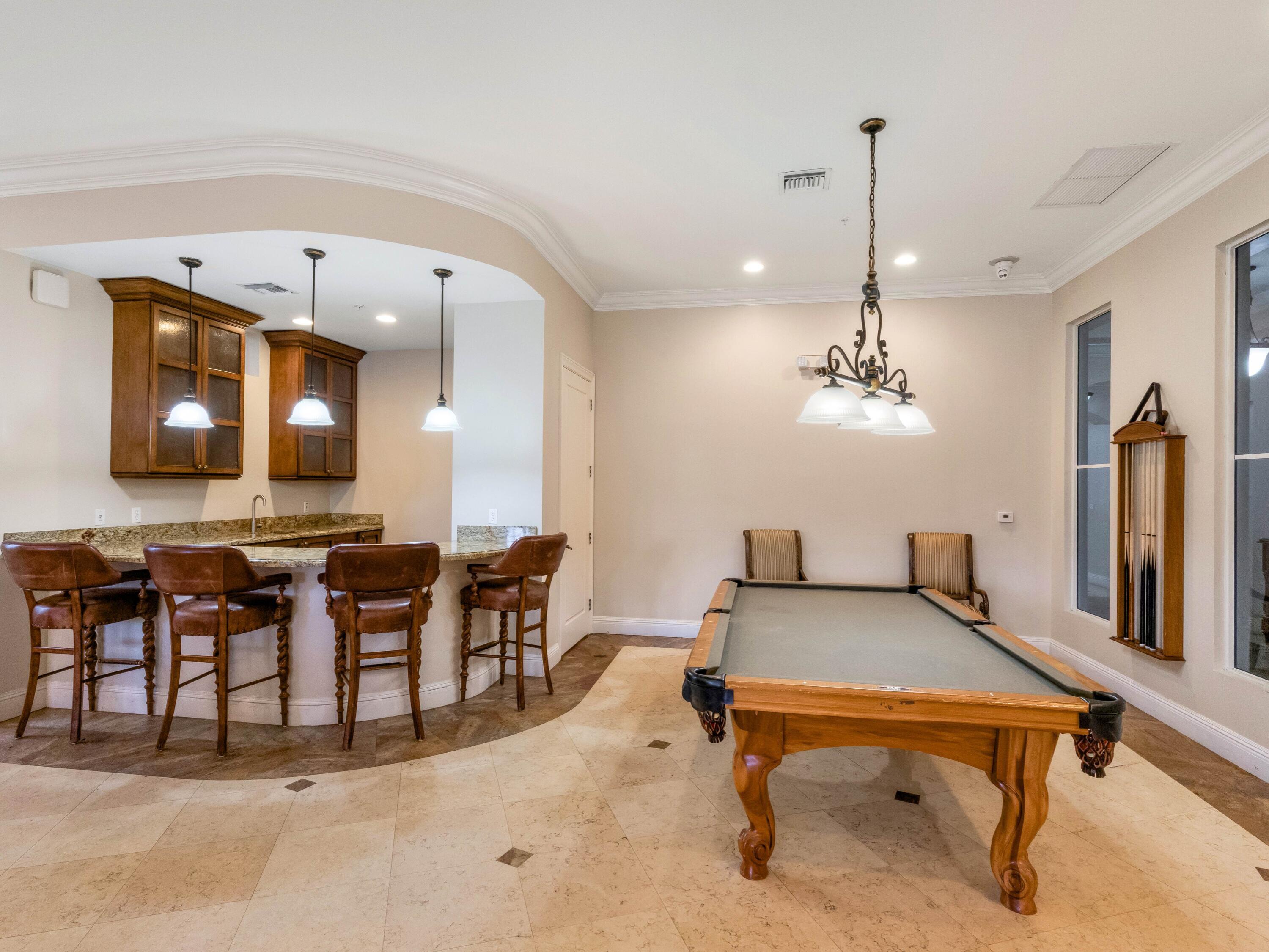 1690 Renaissance Commons Boulevard, Unit 1412 Boynton Beach, FL 33426 - Photo 36 of 49 a room with lots of tables a chandelier and pool view