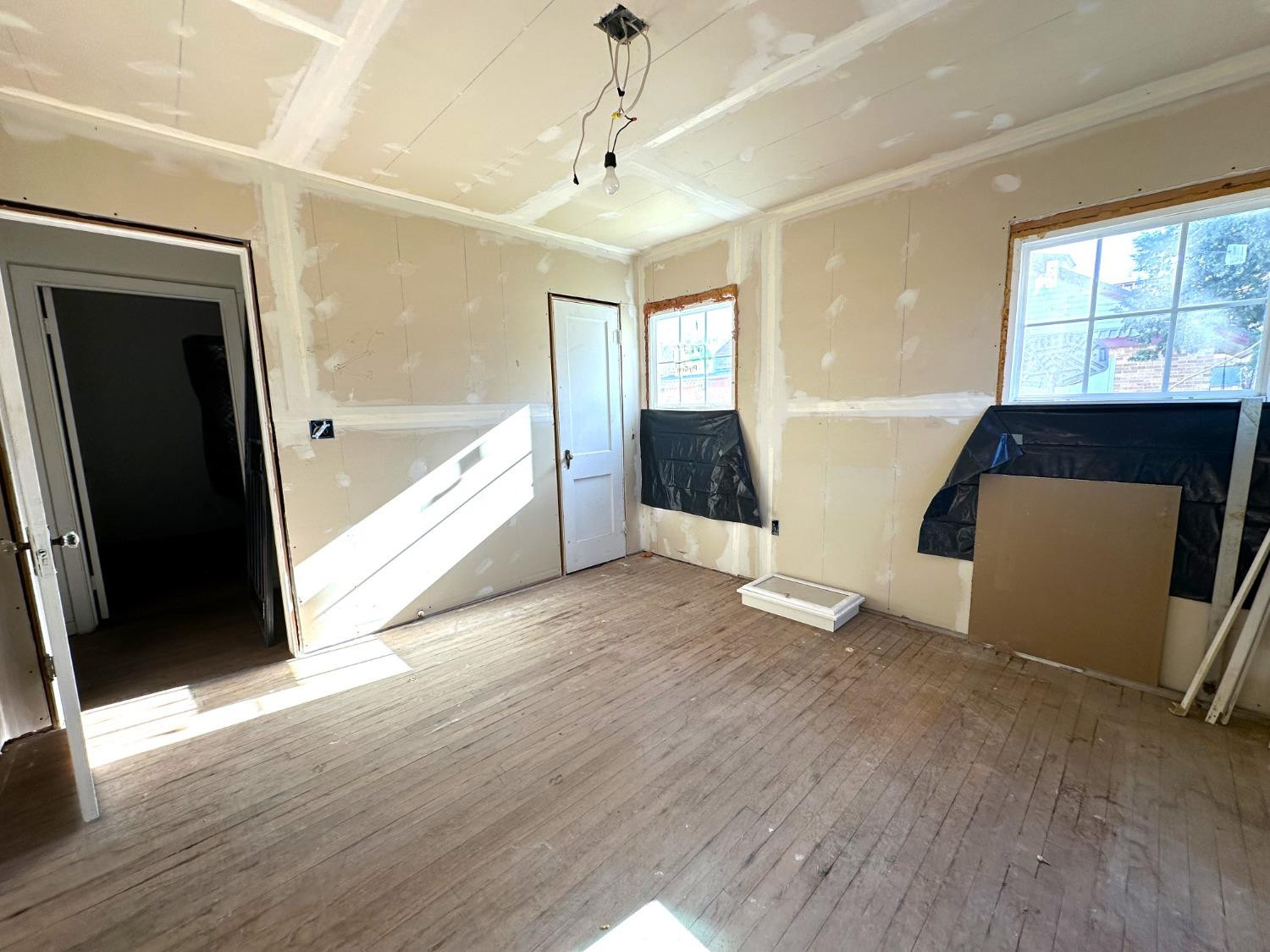 610 Trumbull Avenue Spur, TX 79370 - Photo 10 of 14 a view of an empty room with wooden floor and a window