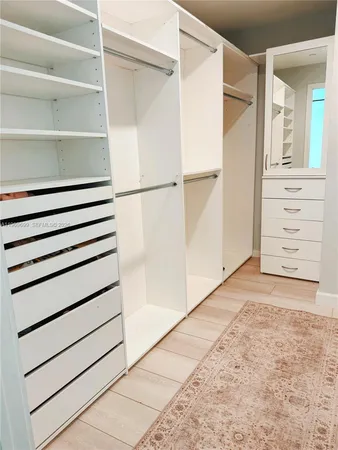 a view of walk in closet with empty racks