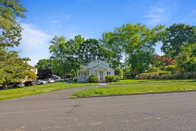 a front view of a house with a yard and trees