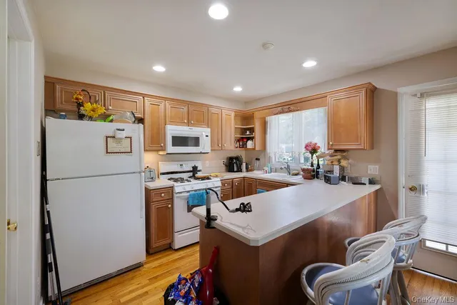 a kitchen with a refrigerator a stove a sink a dining table and chairs