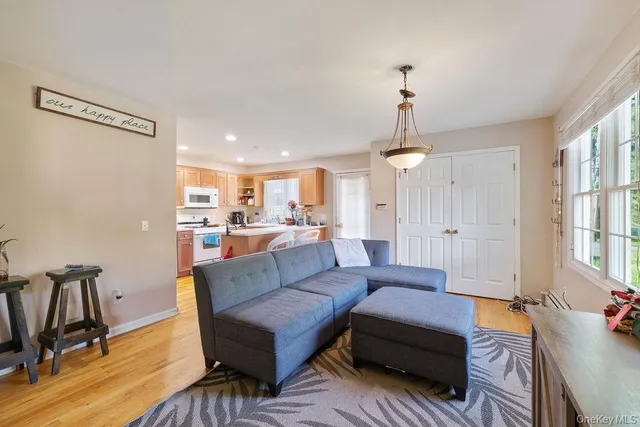 a living room with furniture a window and wooden floor