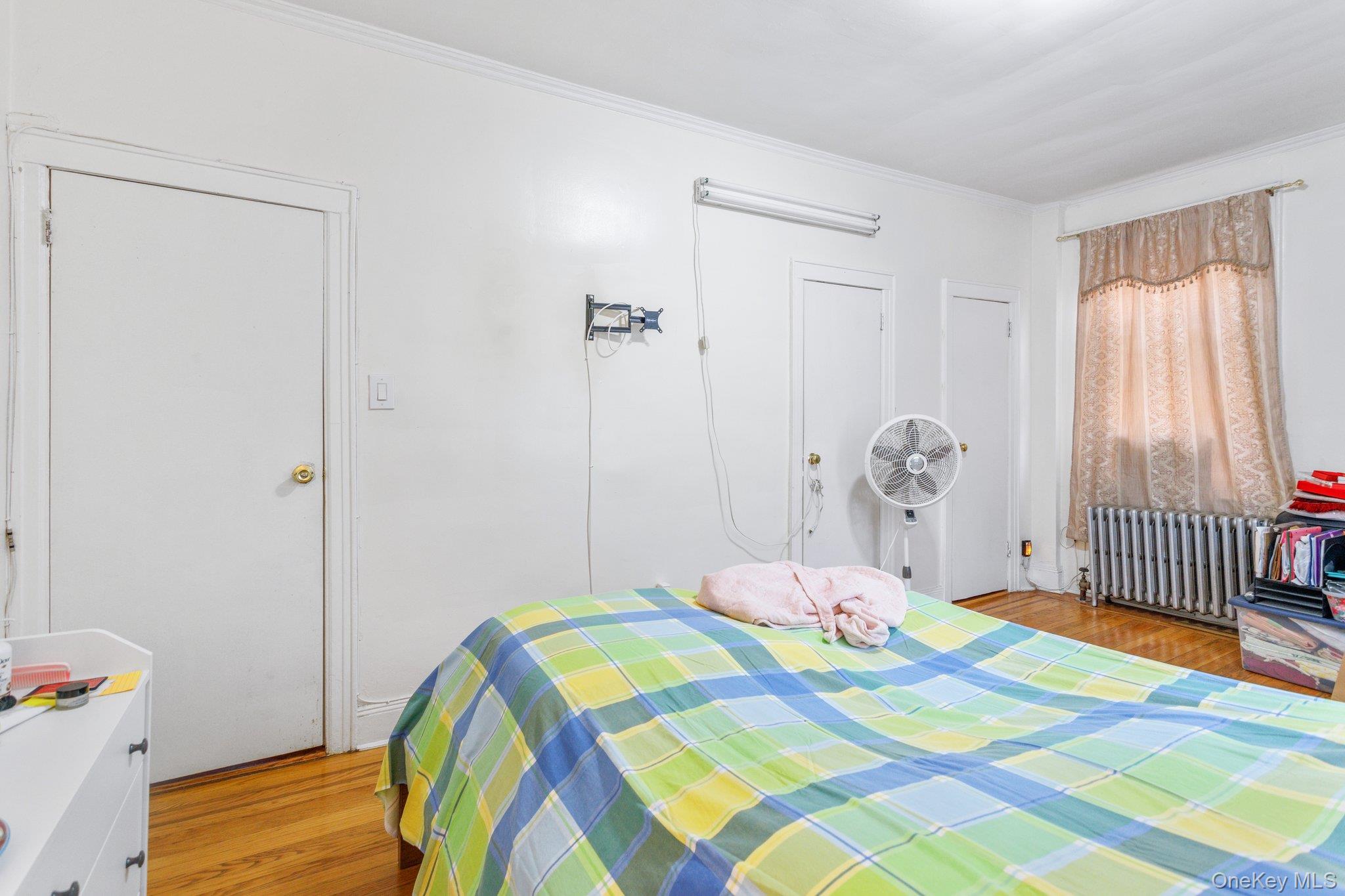 34-29 58th Street Queens, NY 11377 - Photo 11 of 23 a bedroom with a bed and a window