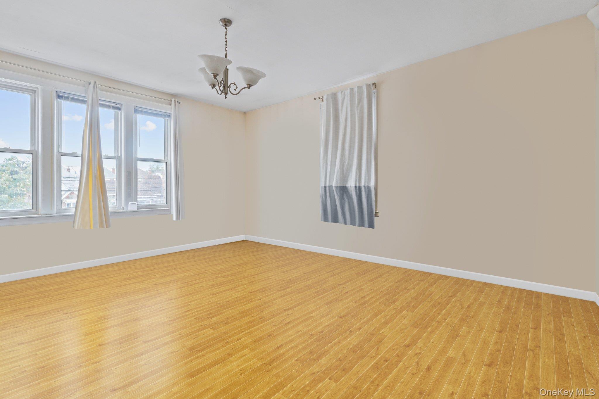 34-29 58th Street Queens, NY 11377 - Photo 14 of 23 a view of empty room with wooden floor and fan