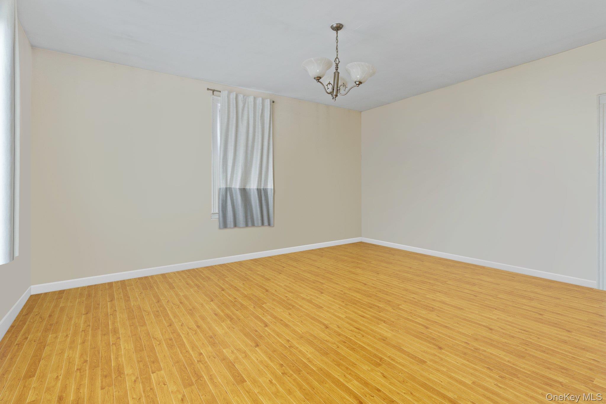 34-29 58th Street Queens, NY 11377 - Photo 15 of 23 a view of empty room with wooden floor and fan