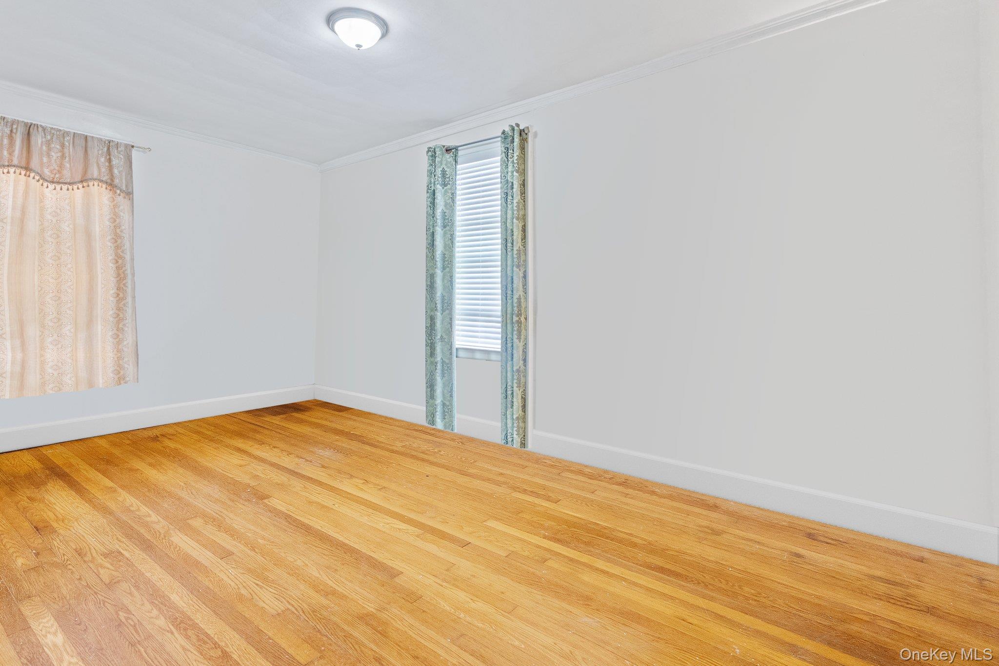 34-29 58th Street Queens, NY 11377 - Photo 20 of 23 a view of empty room with wooden floor and fan