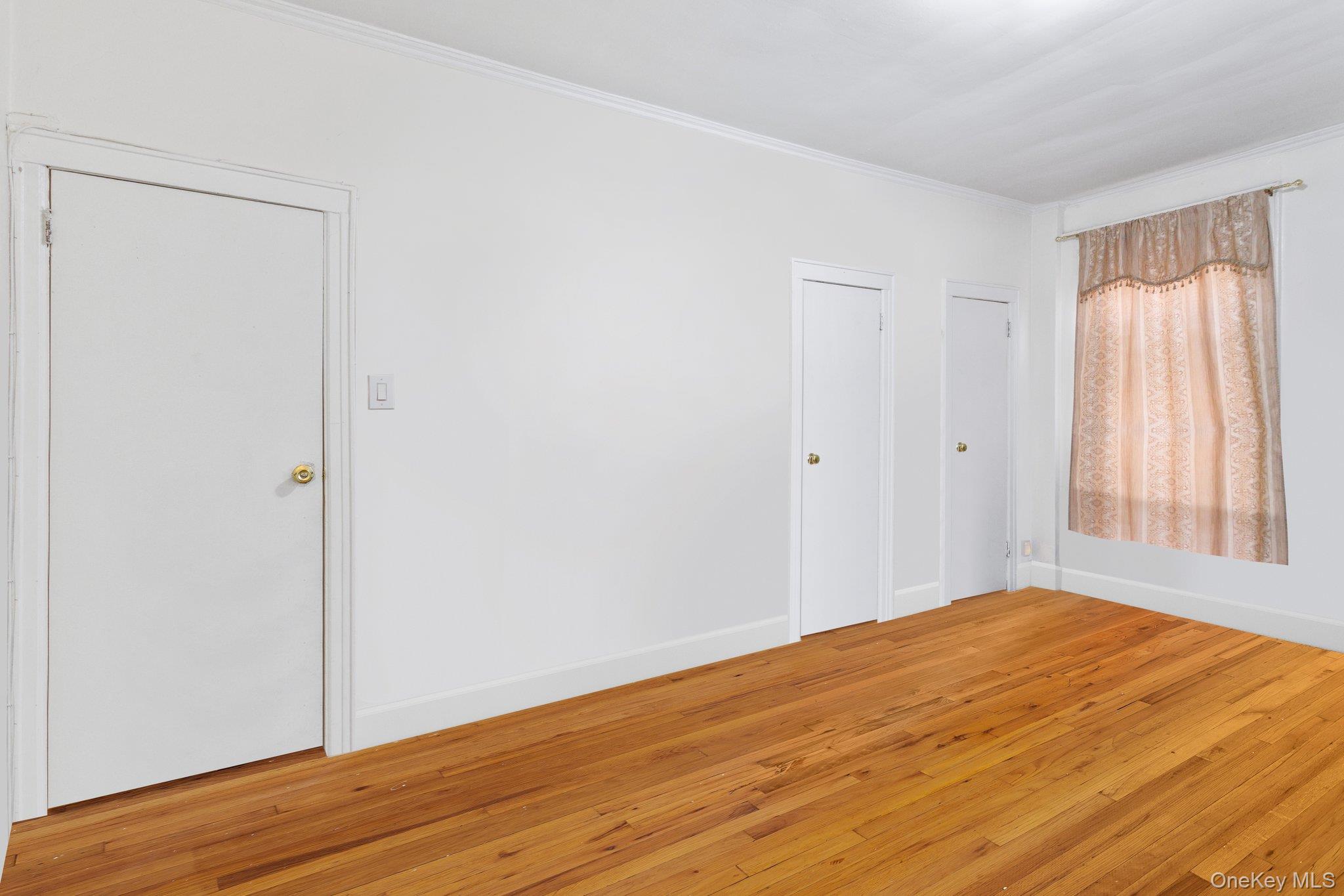 34-29 58th Street Queens, NY 11377 - Photo 21 of 23 a view of empty room with wooden floor and fan