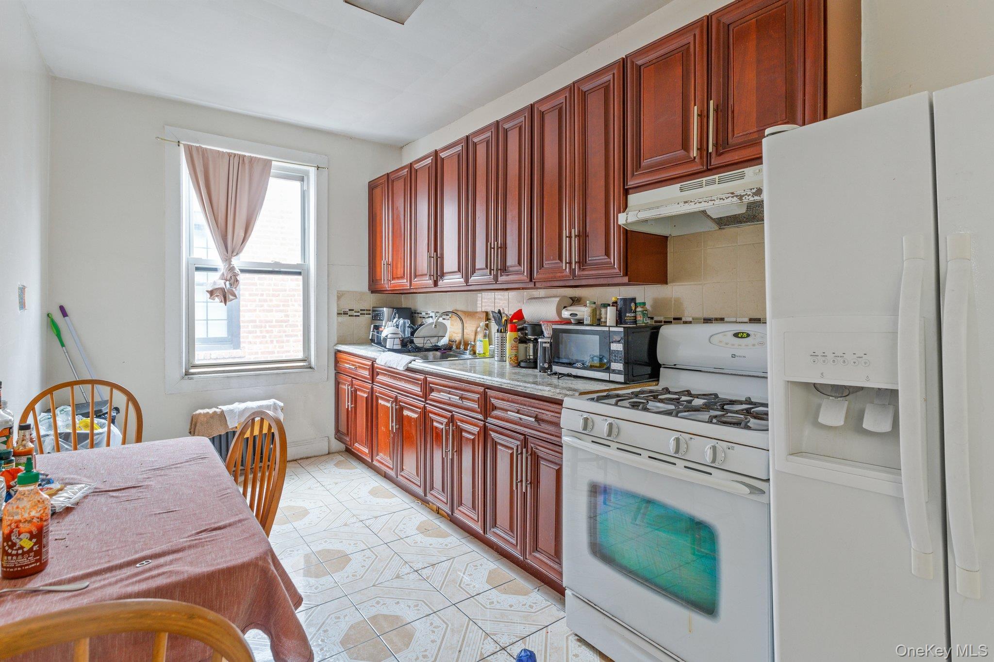 34-29 58th Street Queens, NY 11377 - Photo 6 of 23 a kitchen with stainless steel appliances granite countertop a stove a sink dishwasher and a refrigerator